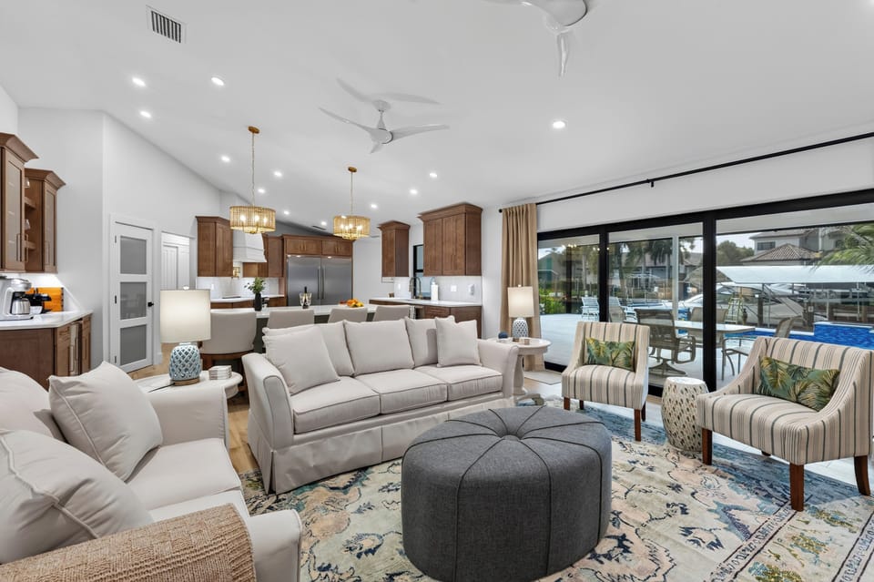 Sunlit living area with large glass sliding doors opening to the patio/pool area.