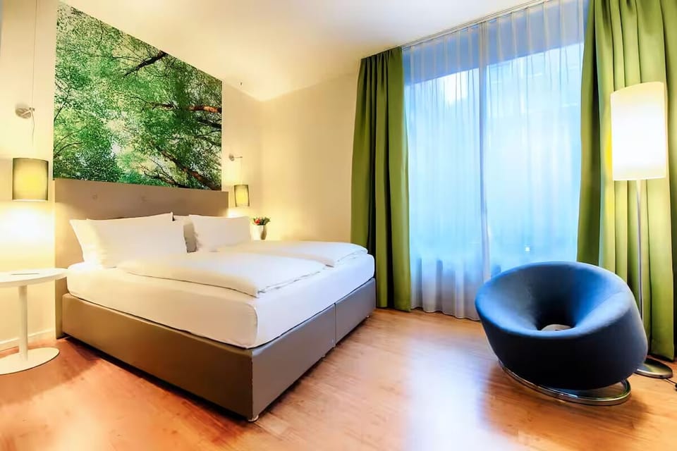 Unwind in crisp linens beneath soothing forest-inspired artwork.