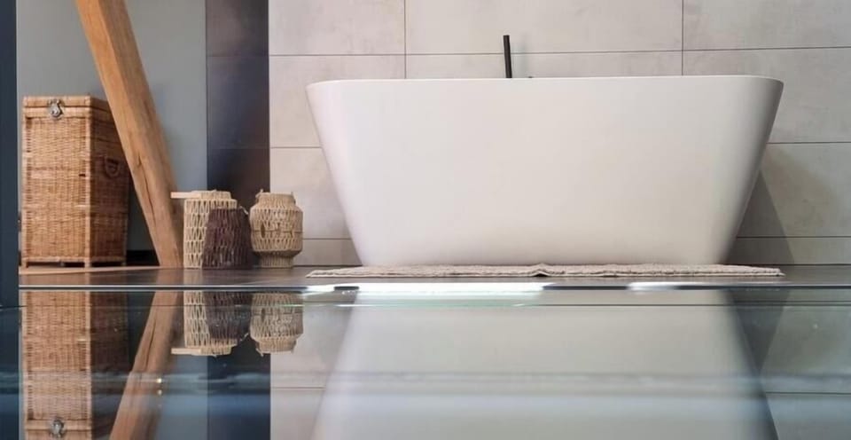 The design bath and its reflection in the glass floor of the night hall, open to the bedroom and bathroom.