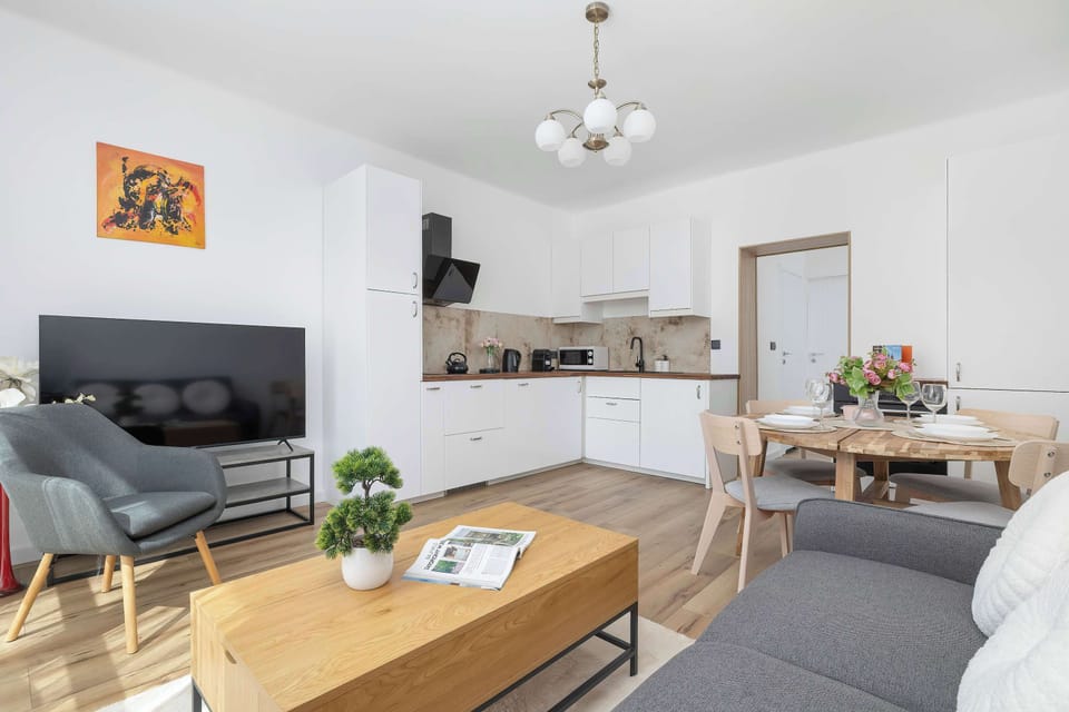 The living area features a sleek coffee table and a flat-screen television.
