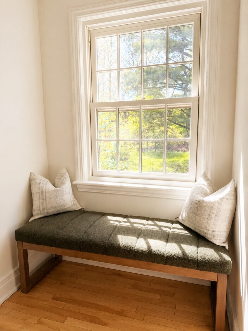 A cozy sunlit reading nook overlooking the peaceful yard.
