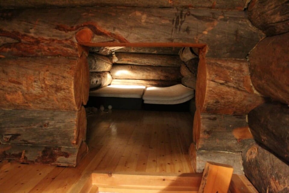 Sleeping nook set into the log wall with its own light.