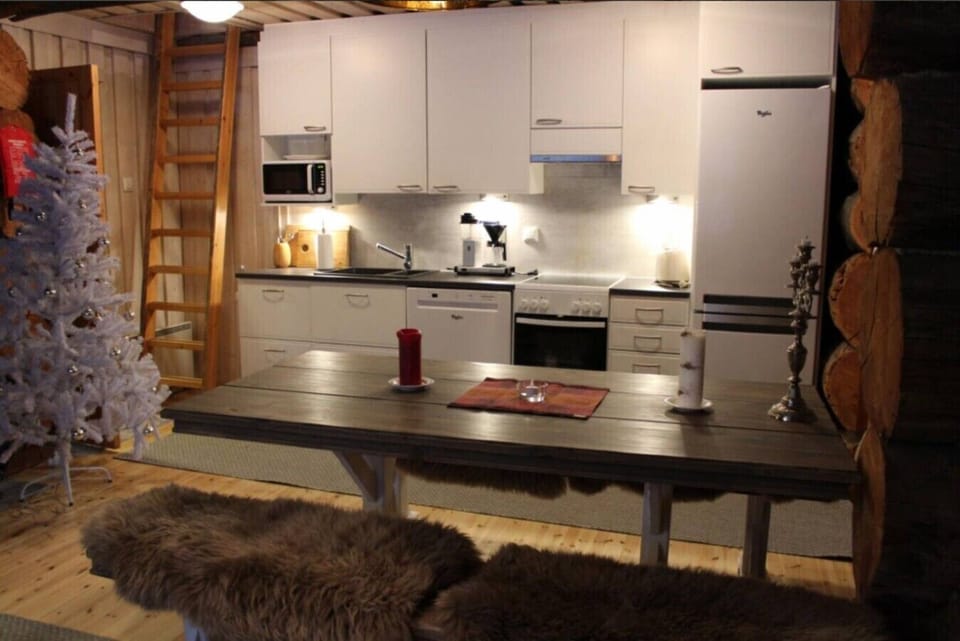 Kitchen with a refrigerator and a dining table for shared meals.