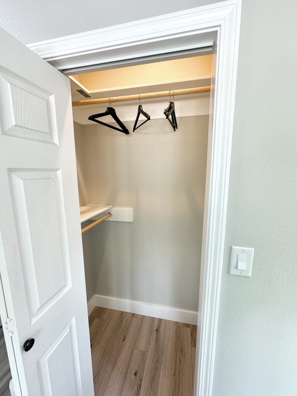Primary closer in master bedroom with hangers and laundry basket.