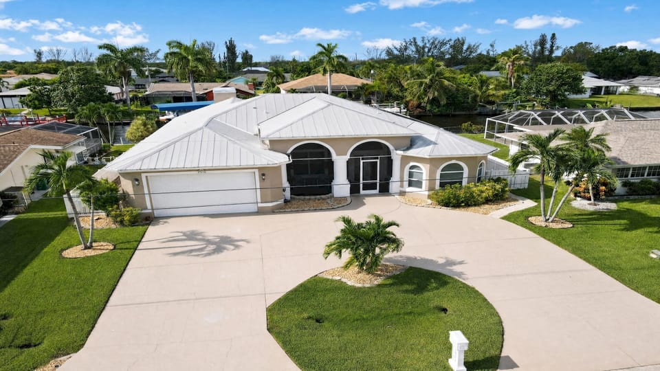Aerial view of Villa Almare in Southeast Cape Coral, showing the spacious property, driveway, and tropical surroundings.