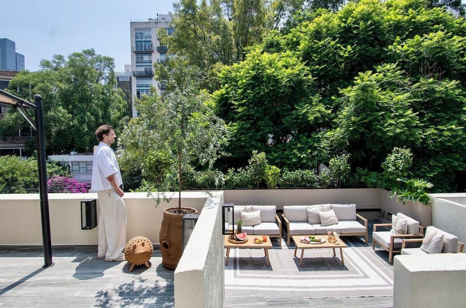 The terrace offers a beautiful perspective surrounded by greenery and neighboring architecture, with ample seating below. Its open layout gives larger groups a comfortable place to gather, socialize and enjoy the outdoors.