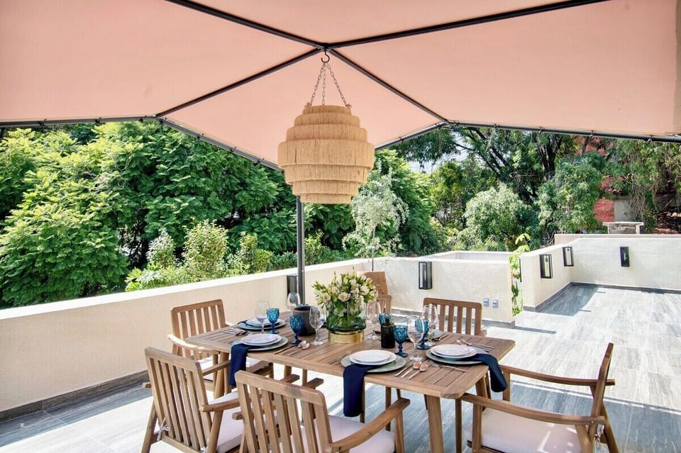 An elegant table setting brings a refined touch to the terrace, making it ideal for memorable meals and special occasions while enjoying the fresh air and verdant surroundings.