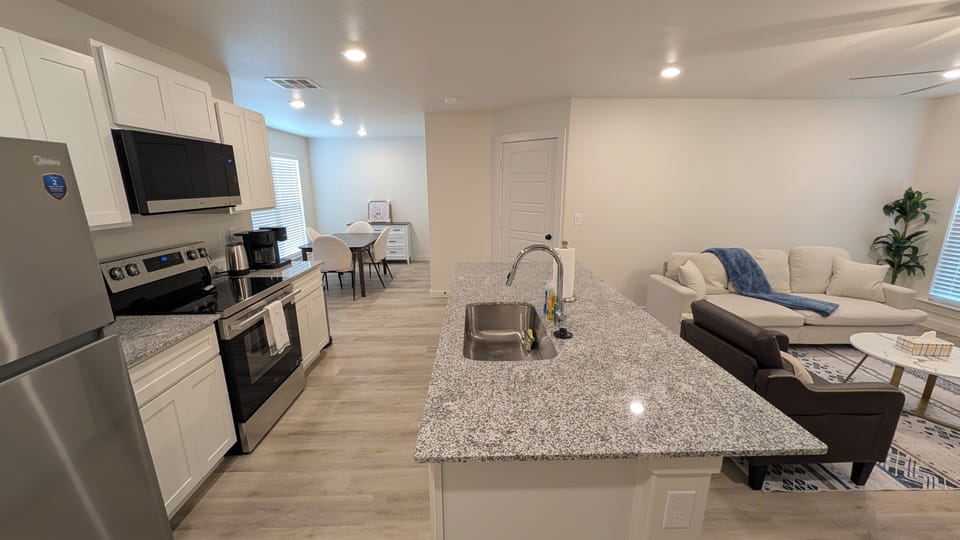 Bright open-concept kitchen and living space with large granite island