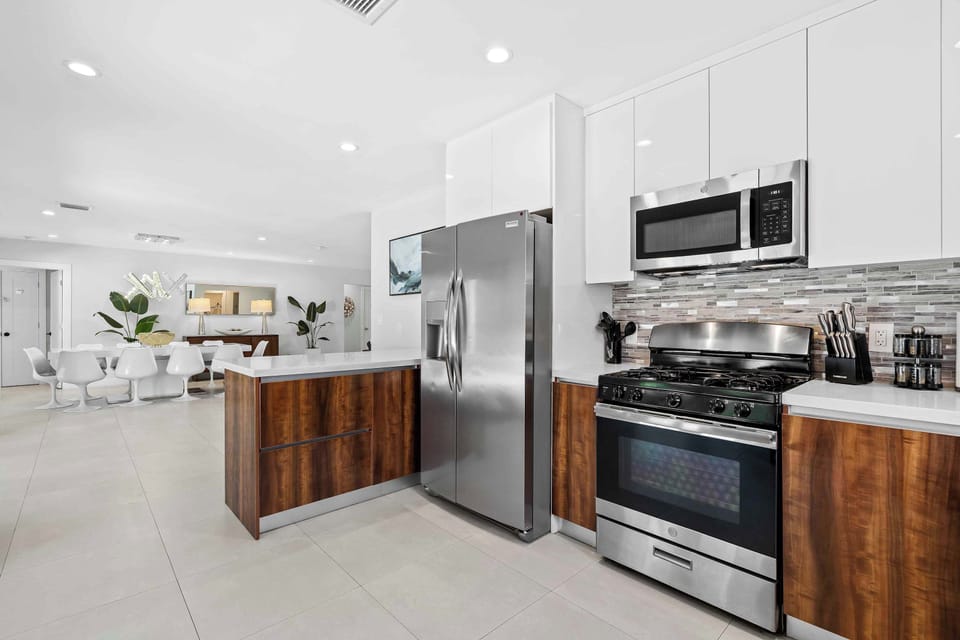 Fully equipped kitchen with modern appliances, a large island with bar seating, and sleek cabinetry.