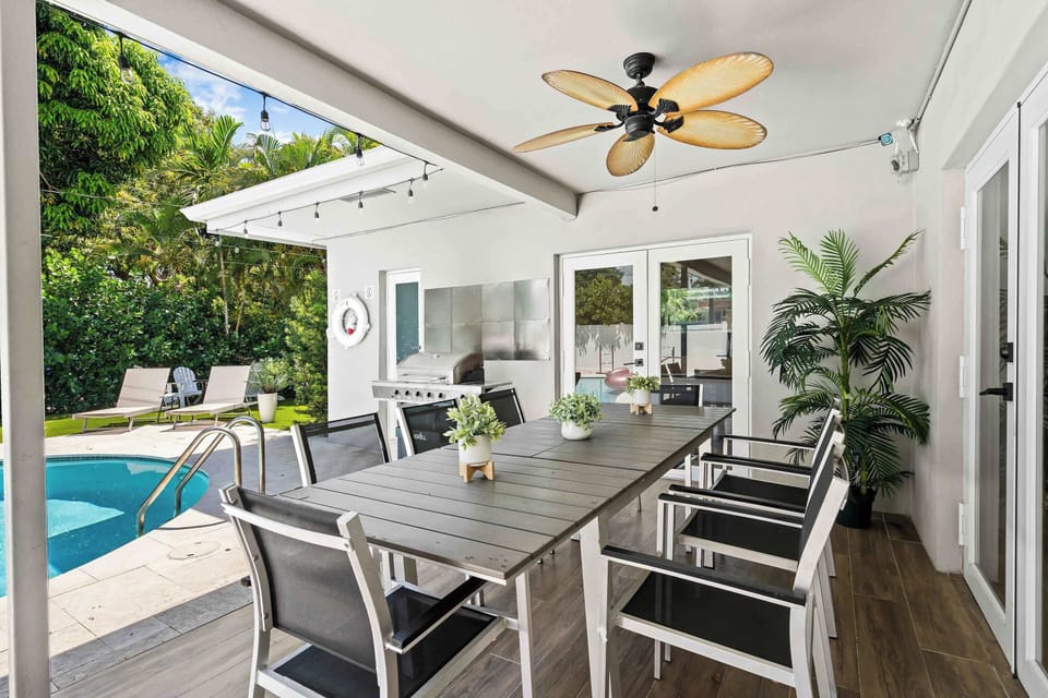 Enjoy al fresco dining under the covered patio equipped with ceiling fans and pool views.