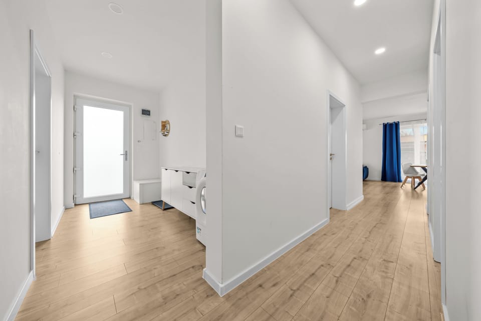 Bright modern entry hall with airy layout and stylish wood-look floors