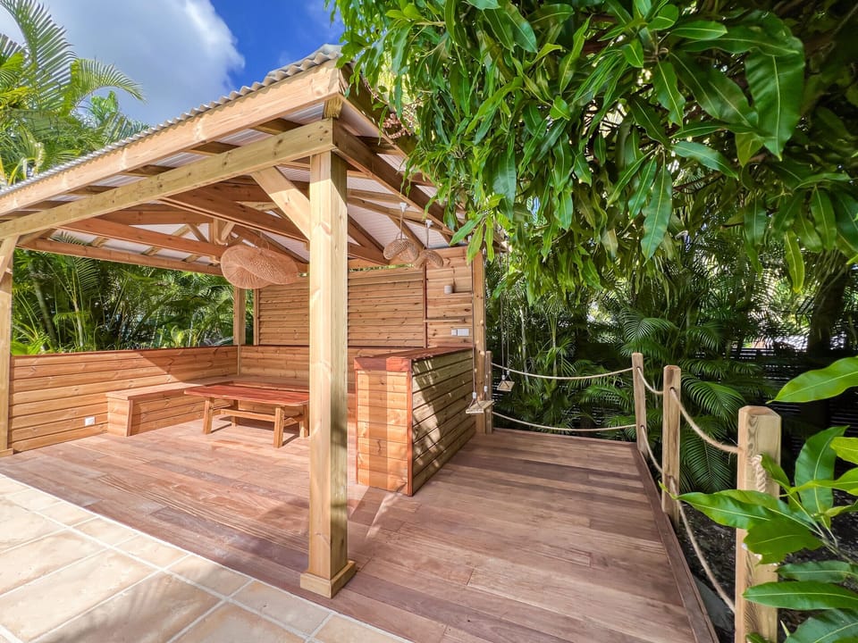 An elegant and spacious teak wood gazebo by the pool, perfect for relaxation.