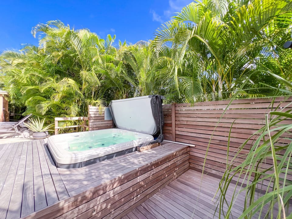 A relaxing jacuzzi on a wooden deck, surrounded by a serene and natural atmosphere.