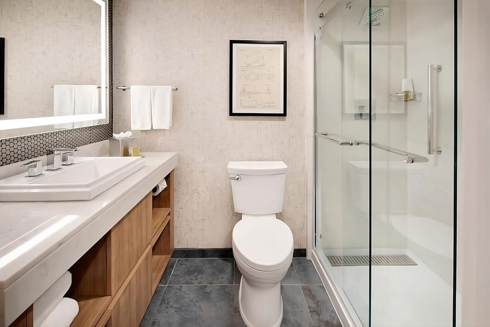 Step into a spotless bath with glass shower enclosure.