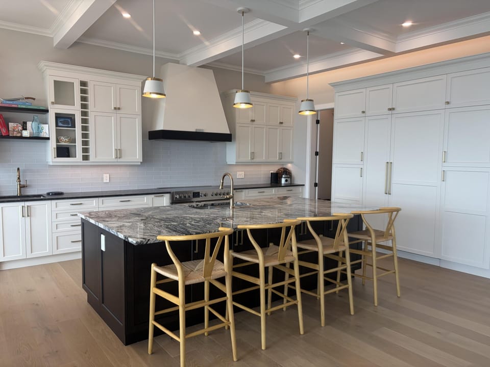 Full chef’s kitchen showcasing custom white cabinetry, stainless appliances, and integrated ice maker.
