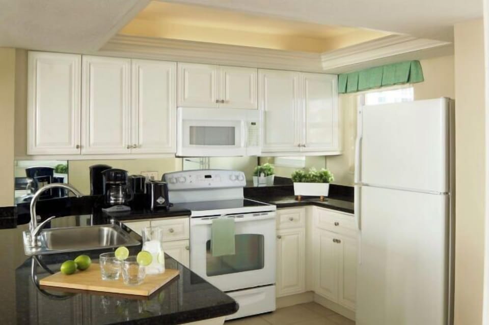 Bright kitchen with granite counters, full appliances, and coffee station