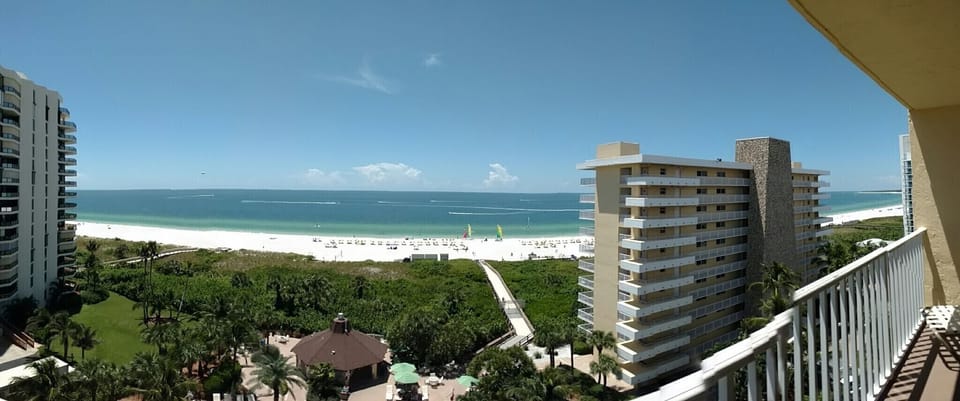 Panoramic balcony view of white-sand beach and turquoise Gulf waters