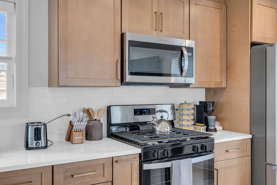 Bright modern kitchen with gas range, coffee station, and sleek finishes
