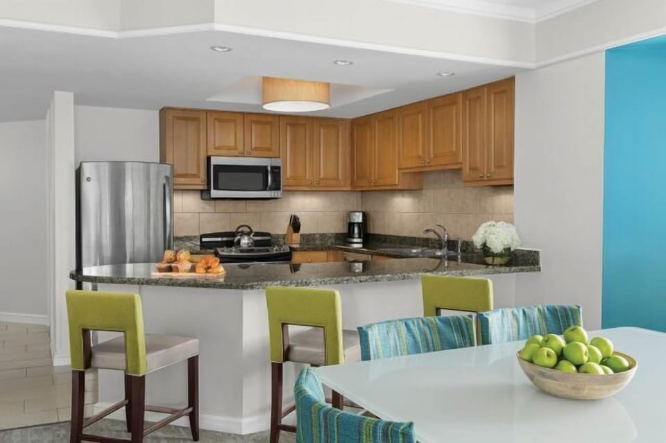 Bright open kitchen with granite breakfast bar and modern dining area