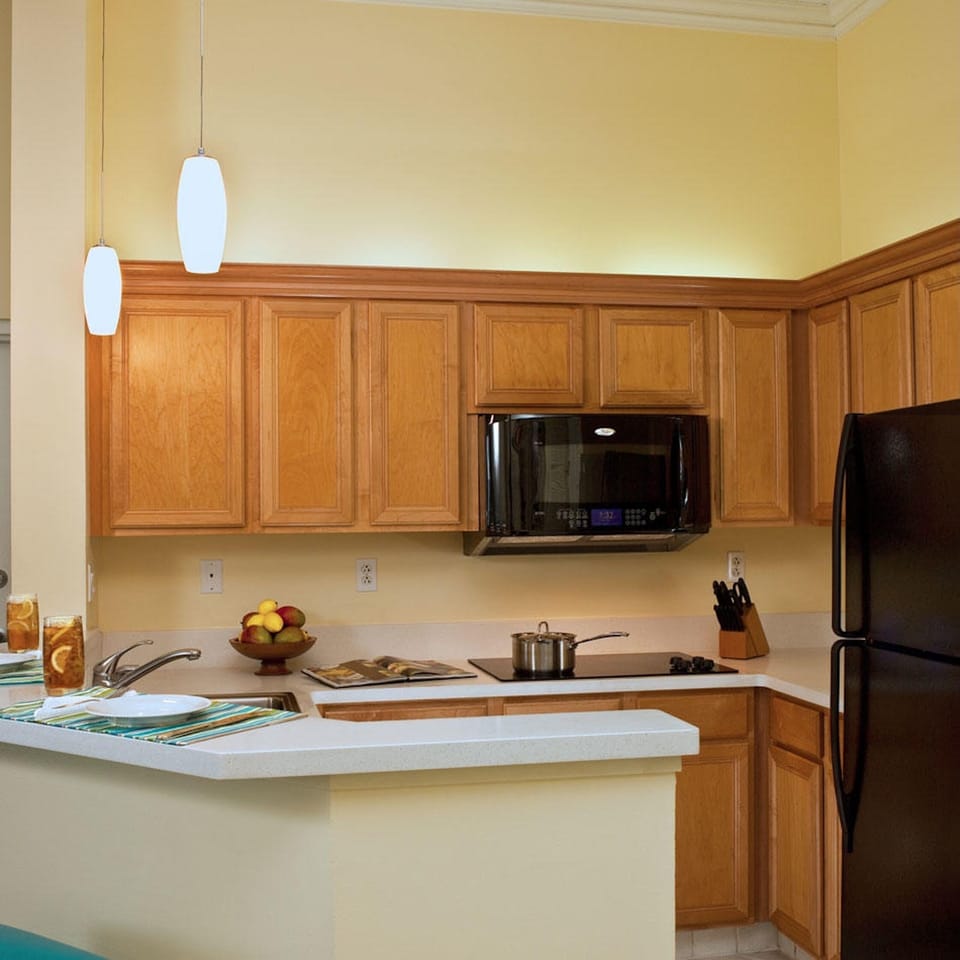 Bright kitchen with breakfast bar, warm wood cabinets, and modern appliances