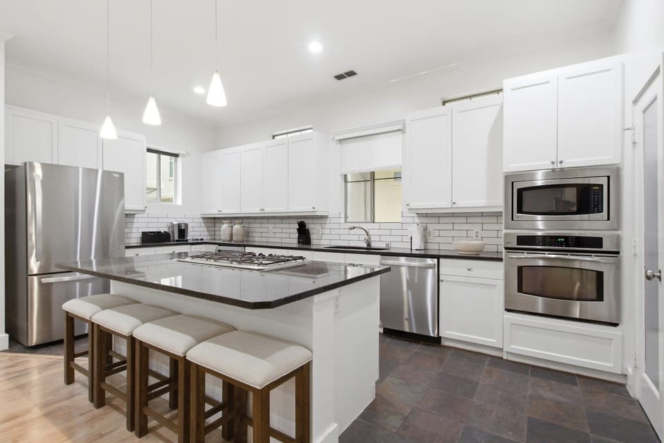 Fully equipped kitchen with stainless steel appliances, gas range, built-in microwave, and island seating. Ready for everything from a quick breakfast to a full dinner spread.
