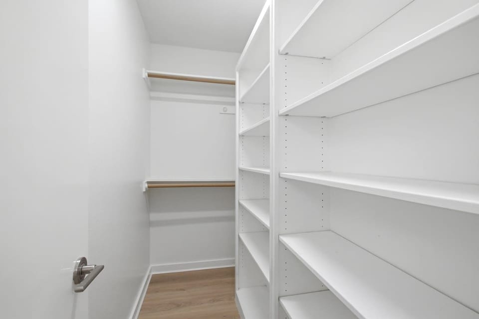 Third-floor bedroom with Queen bed, ceiling fan, walk-in closet, and warm neutral tones throughout. Comfortable and quiet, with easy rooftop access just around the corner.
