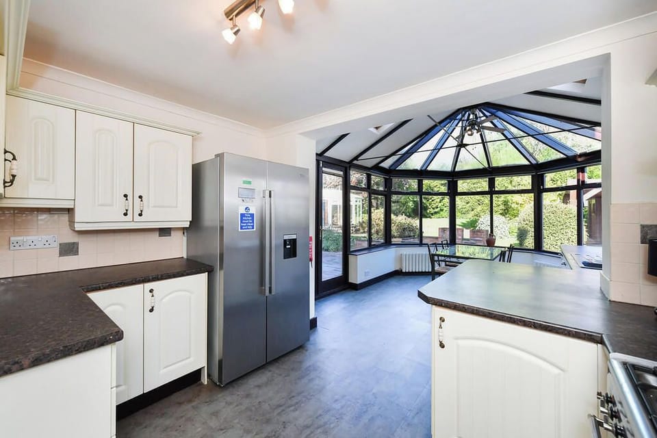 Modern kitchen & conservatory with comprehensive appliances & kitchenware.