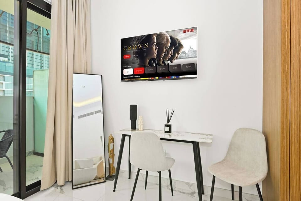 Bright, elegant bedroom with marble floors, soft beige tones, Smart TV with Prime Video, and a private balcony — perfect for relaxing mornings or cozy nights in the city skyline.