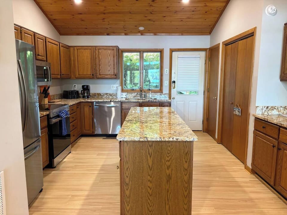 Well stocked kitchen with island and newer (2023) stainless steel appliances.  Open to dining and living room.