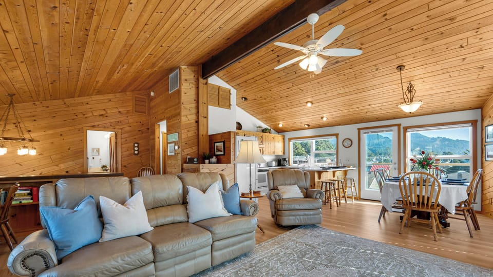 Relax in this inviting open-concept space with vaulted wood ceilings, comfortable leather seating, and stunning mountain views through expansive windows.