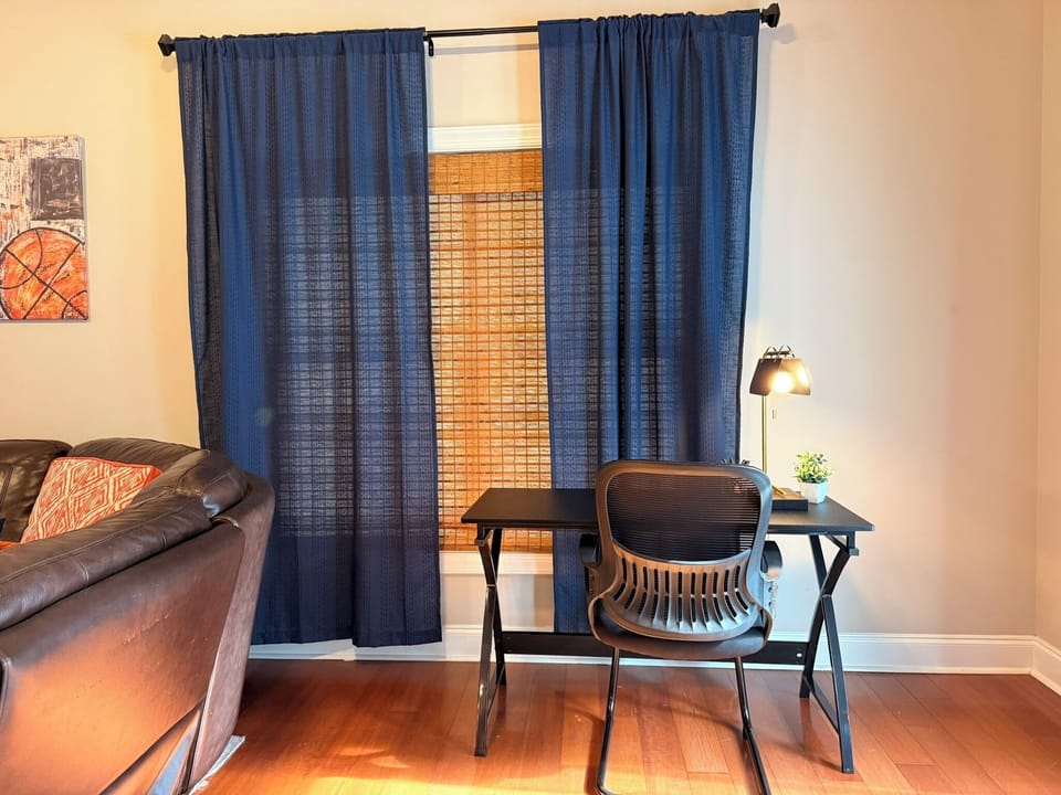 Bright window-side workspace with desk, lamp, and comfortable seating