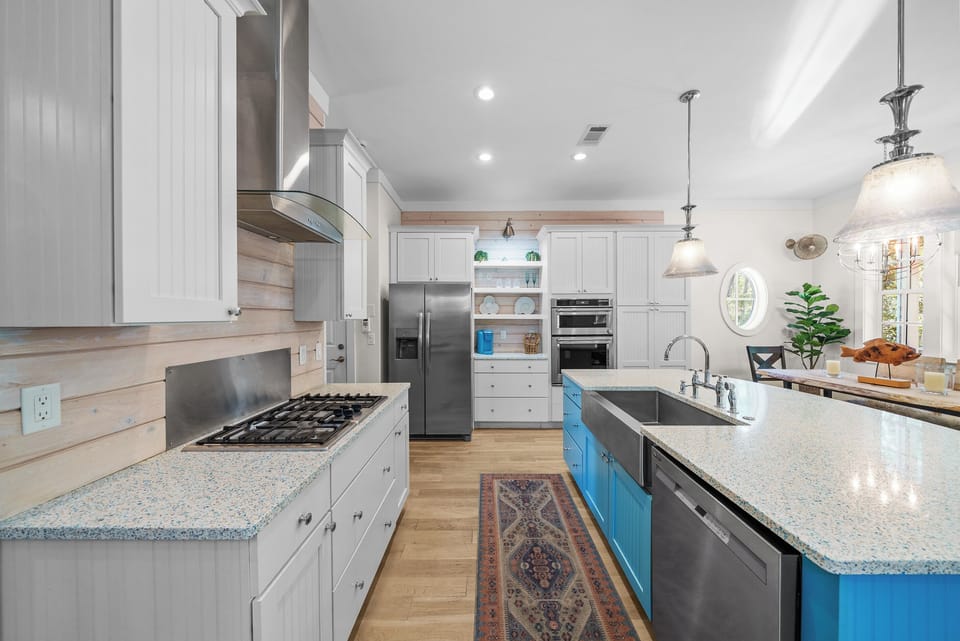 Gas cooktop, wall oven with built-in microwave, dishwasher, and a full size side-by-side refrigerator. Everything here to cook a real meal, not just reheat one.