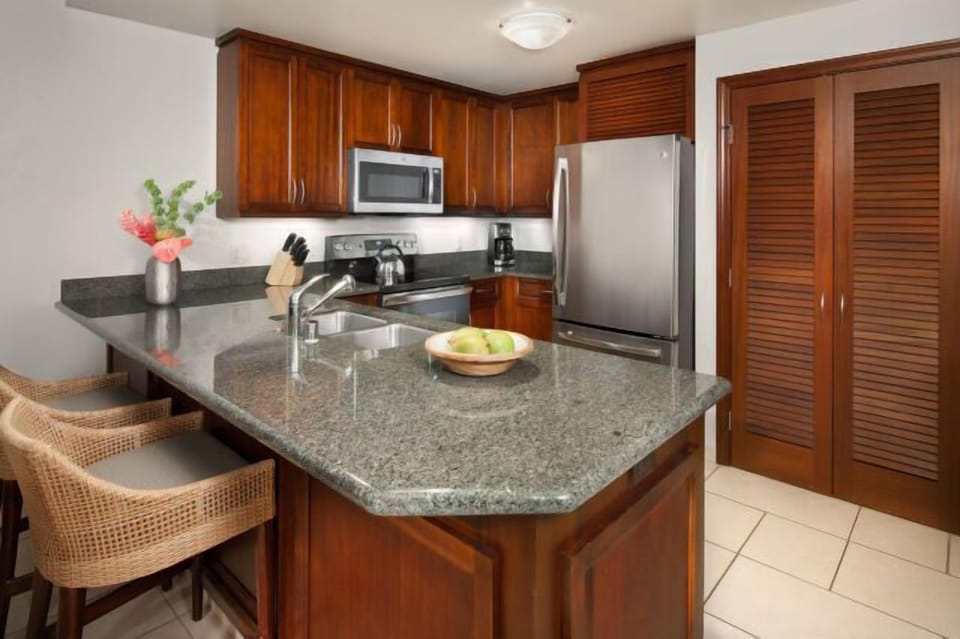 Spacious granite kitchen with island seating and stainless appliances