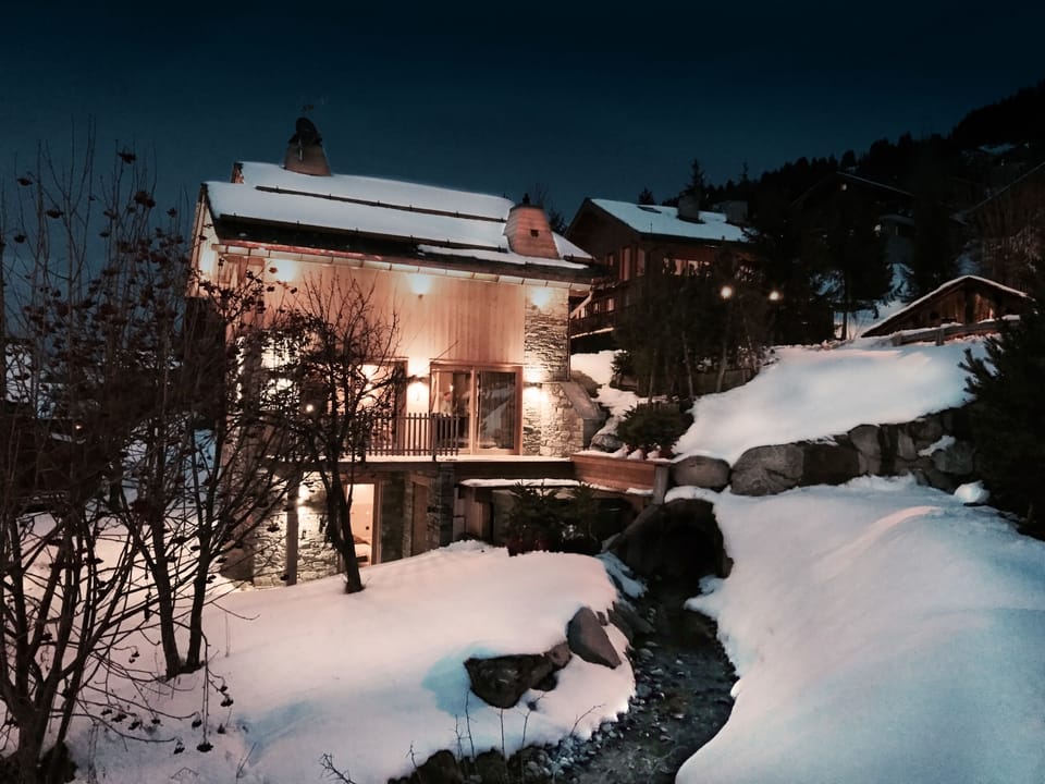 Chalet Caro exterior with hot tub and stream
