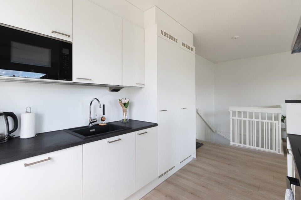 Modern kitchen with black sink, microwave, and full-height storage, Padisentie 8 C 12
