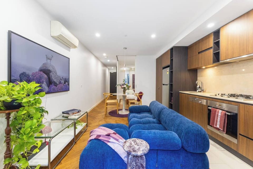 Take in the full flow of the apartment, where living, dining, and kitchen spaces connect in one long, open plan.