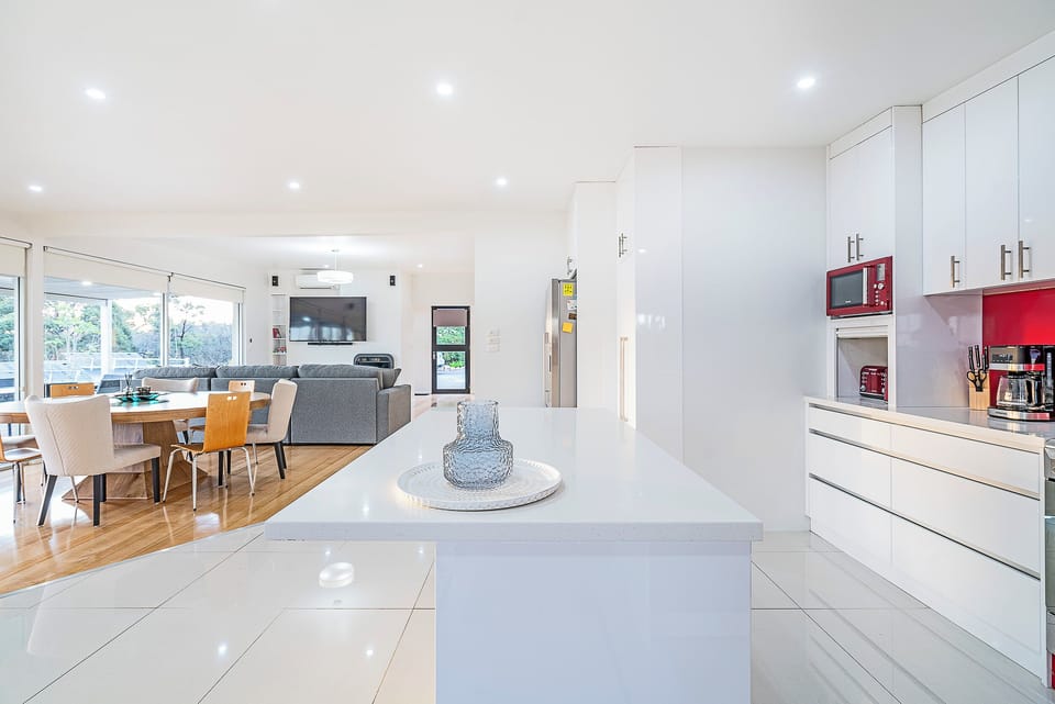 The open-plan design keeps everyone connected, allowing conversation to flow naturally between the kitchen, dining, and living spaces.