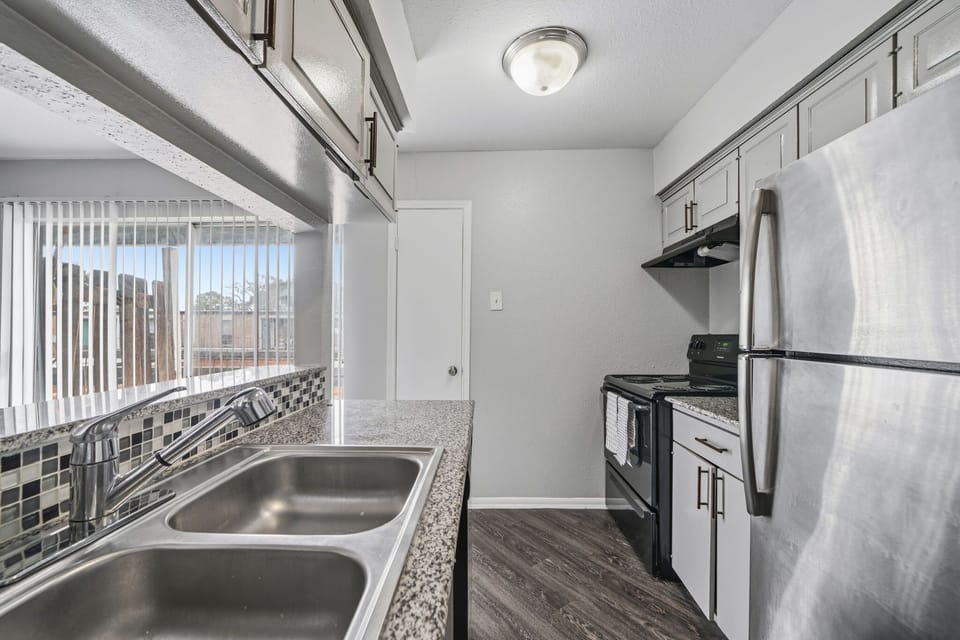 Private kitchen with stainless-steel appliances, granite-look counters, and a bright window view for easy meal preparation.