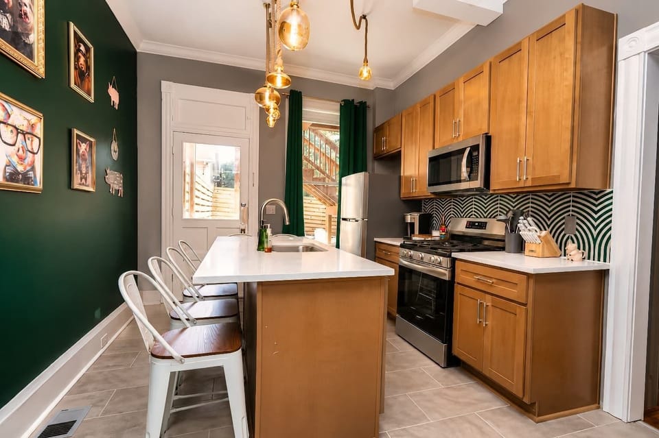 Fully stocked kitchen with generous counter space and island seating for casual meals and conversation