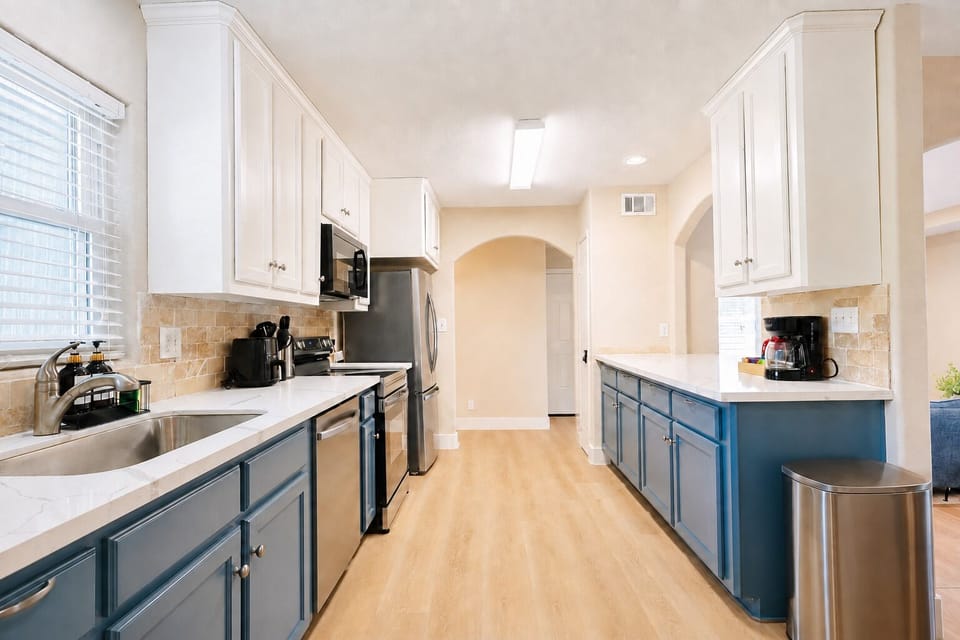 Bright modern kitchen with stainless appliances and stylish blue cabinetry