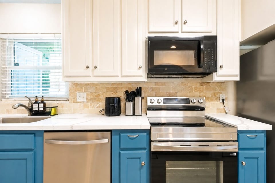 Bright modern kitchen with stainless appliances and stylish blue cabinetry