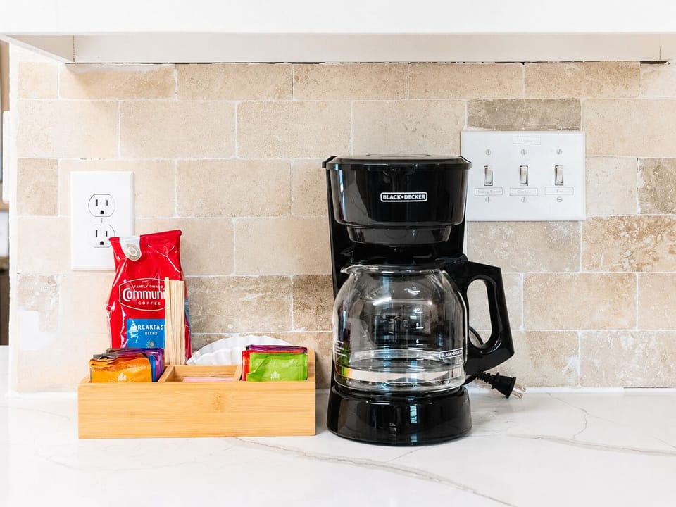 Guest-ready coffee station with organized essentials and stylish backsplash