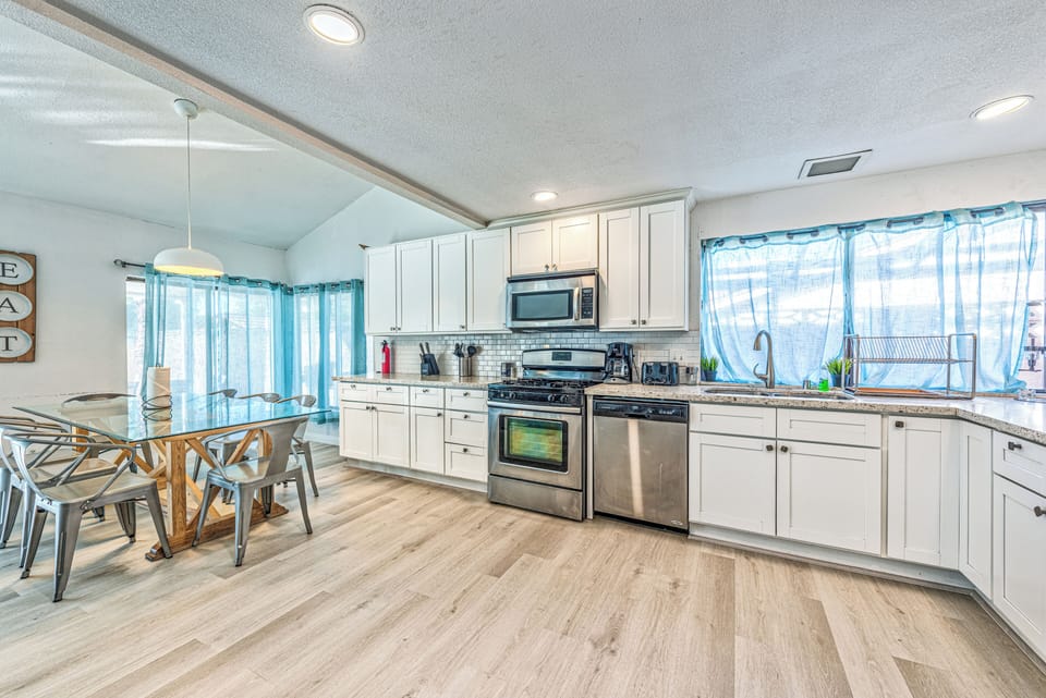Bright open kitchen with stainless appliances and sunny dining space