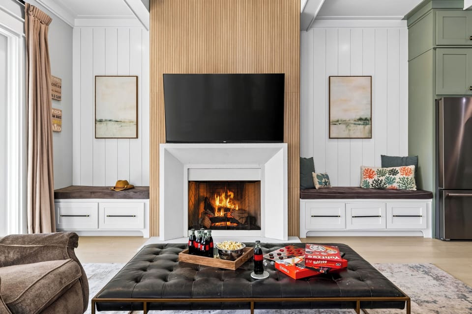 Built-in bench seating flanks the fireplace and TV, creating a cozy spot for movie nights, snacks, and friendly board-game competition.