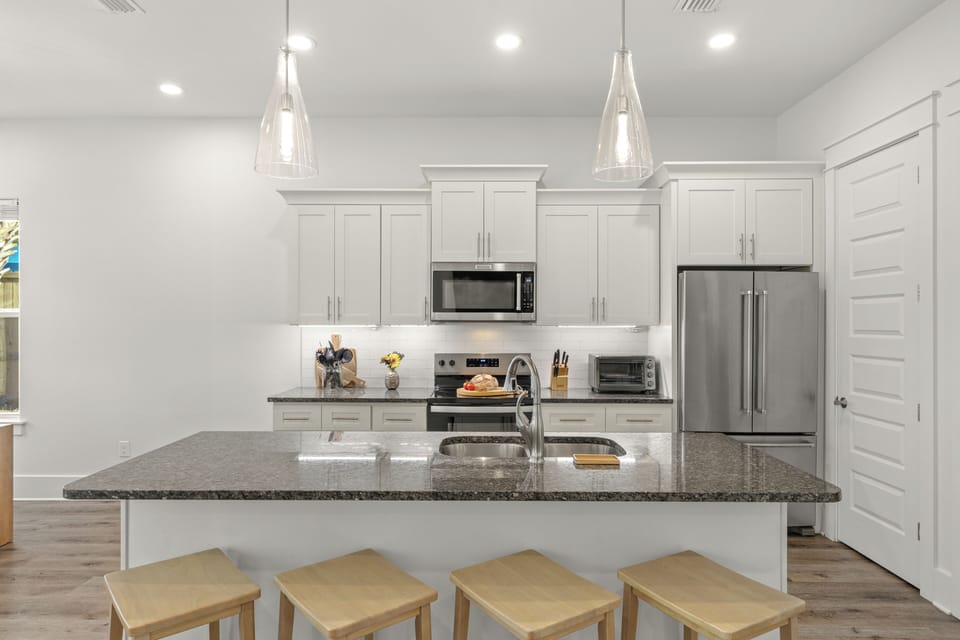 A sleek kitchen centers around a spacious island with seating for four, offering plenty of room for meal prep, casual bites, and conversation.