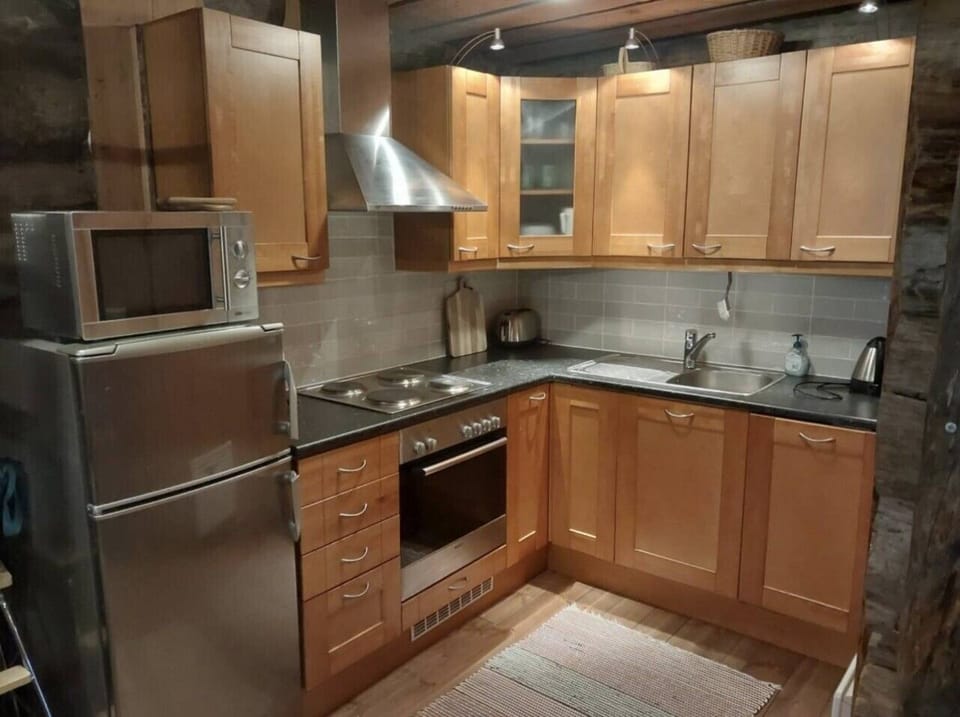Kitchen equipped with an electric stove and oven, microwave and refrigerator.