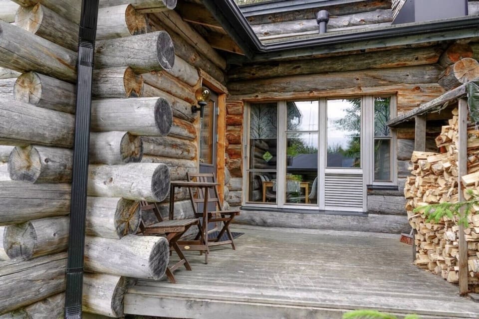 Sheltered wooden terrace with a seat and firewood stacked ready for the fireplace.