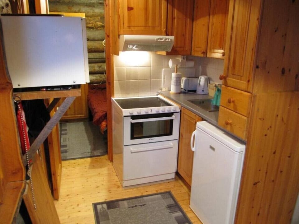 Compact kitchen equipped with an electric stove, oven, microwave and refrigerator.