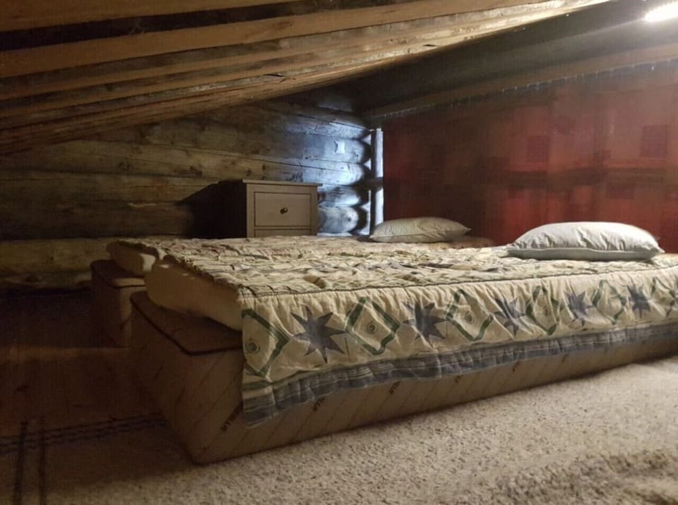 Loft sleeping area with beds tucked under the wooden roof.
