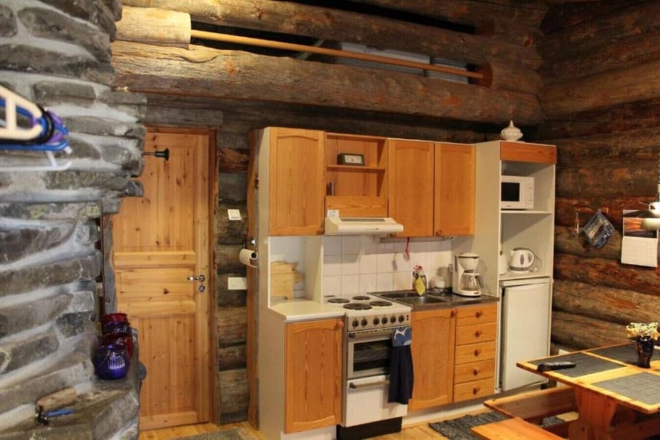 Kitchen with wooden cabinets, an electric stove with oven, a microwave and a coffee maker.
